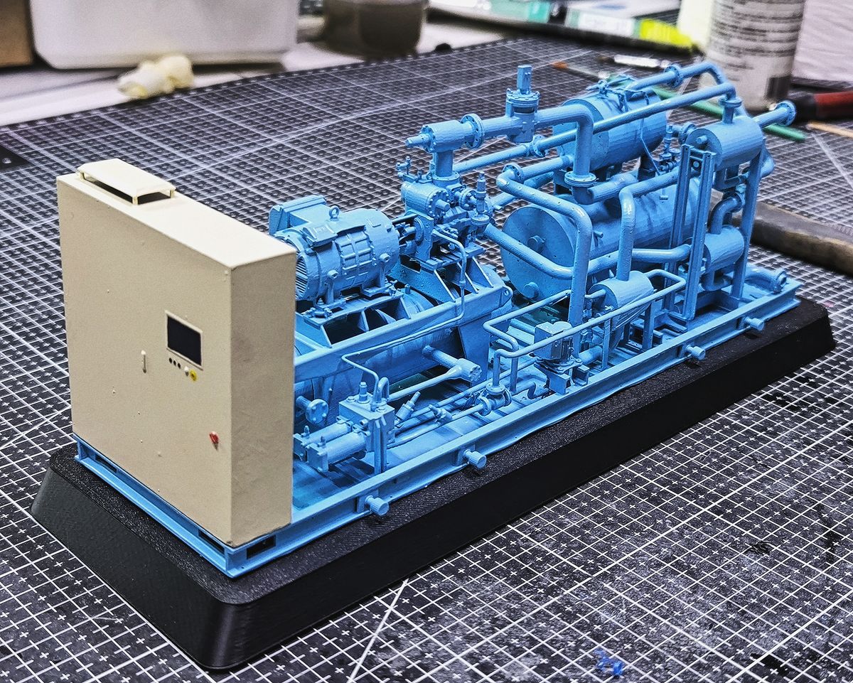 Maqueta de una planta compresora sobre base, con tableros y cañerías a escala